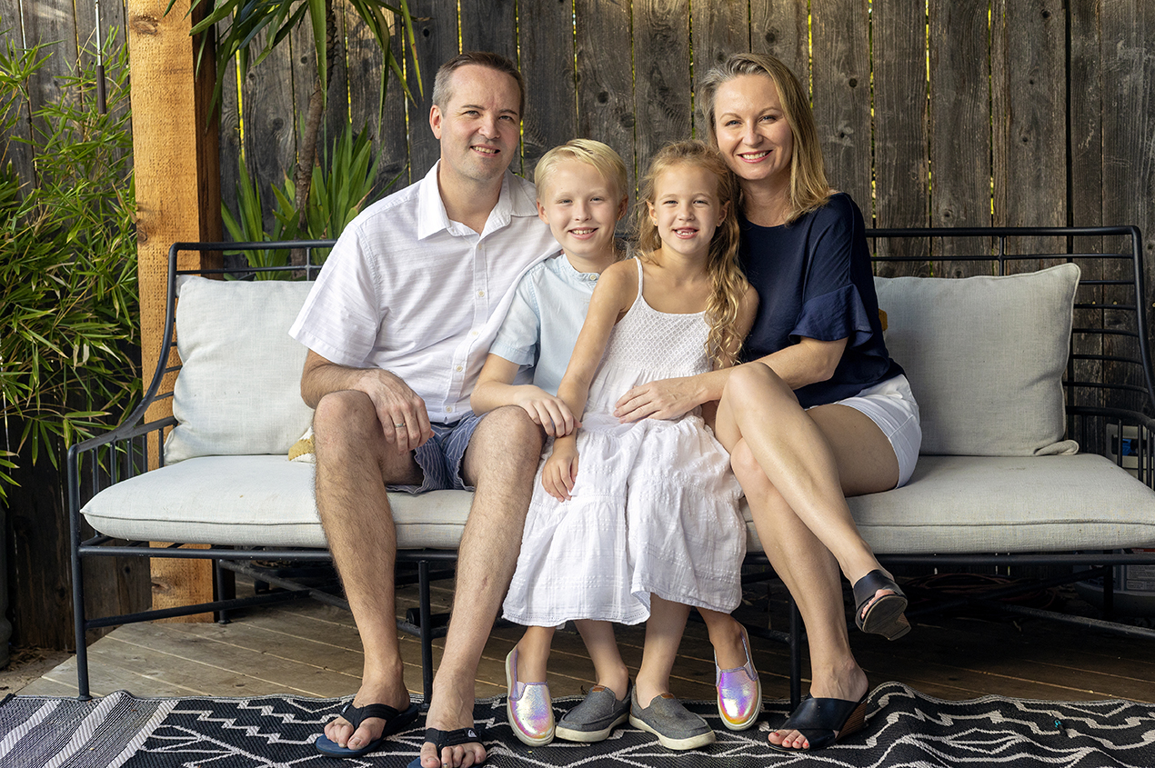 family of four seated on couch for their at-home family photo session in Austin, Texas