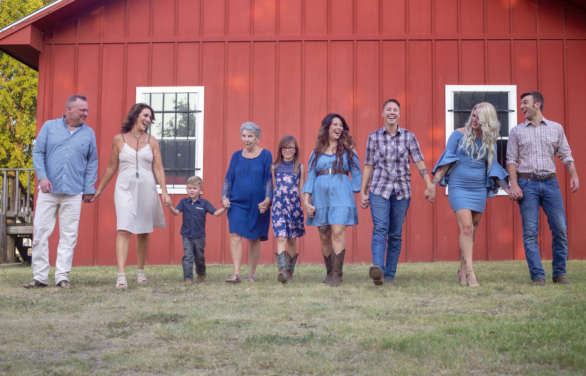 extended family photo session in front of a red barn in texas