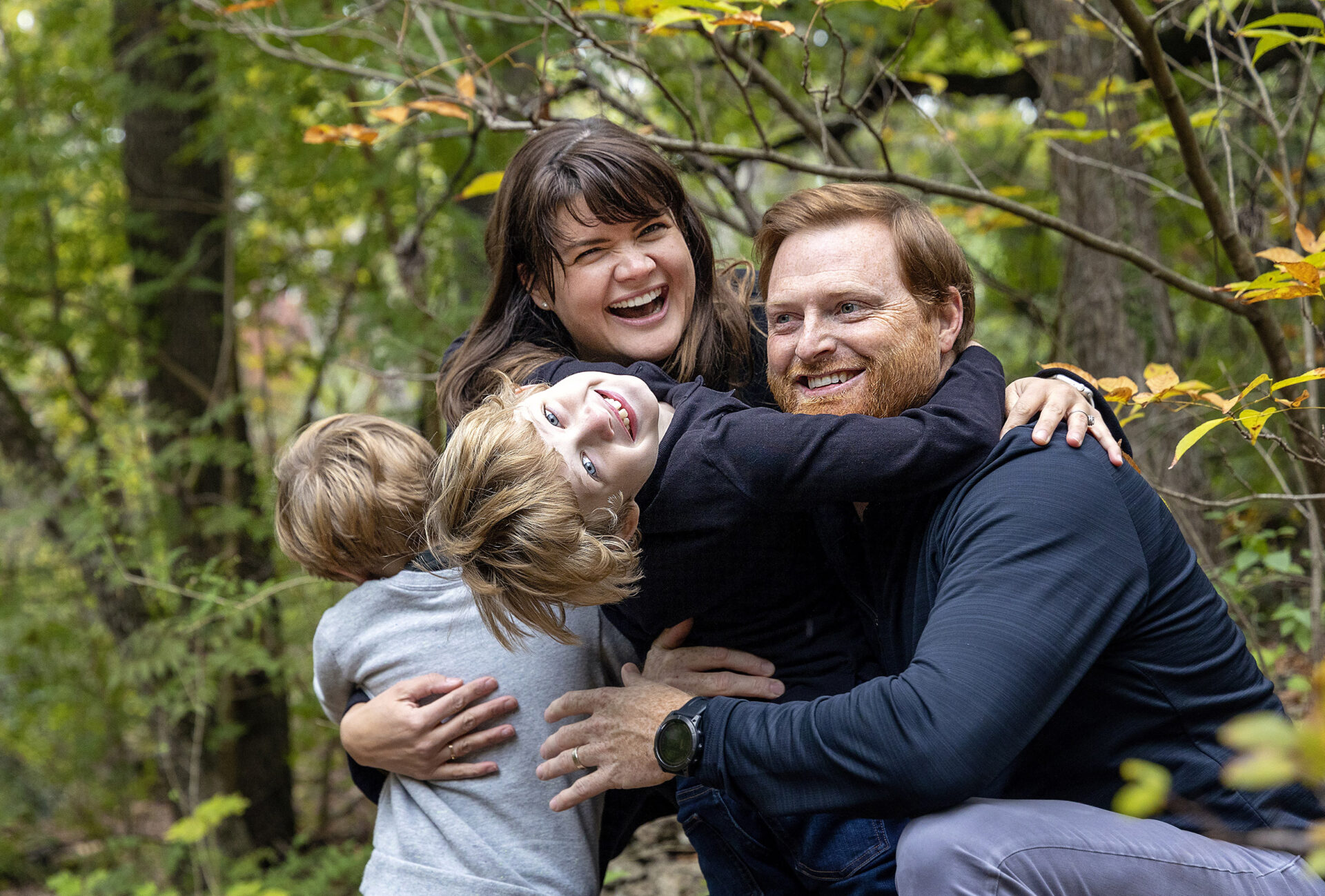 family hugging during their photo session in the park in austin, texas