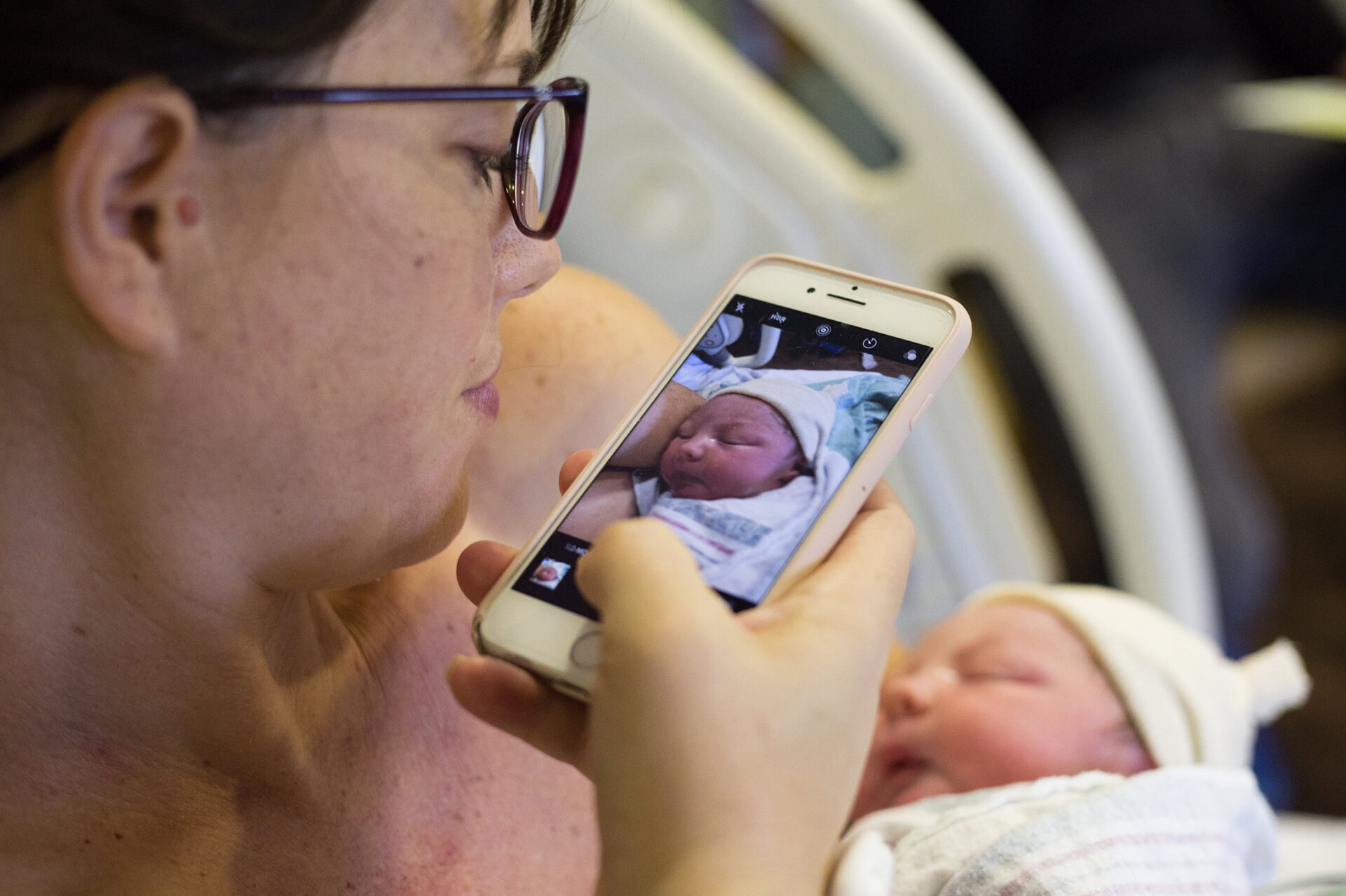 mom taking an iphone pic of her newborn son in the hospital