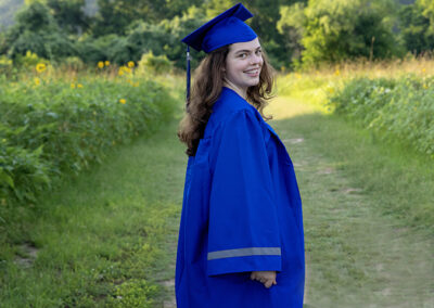 high school senior in blue cap and gown for graduation photos