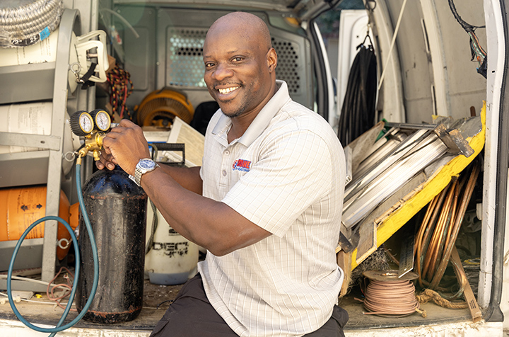 AC repairman in van holding tank