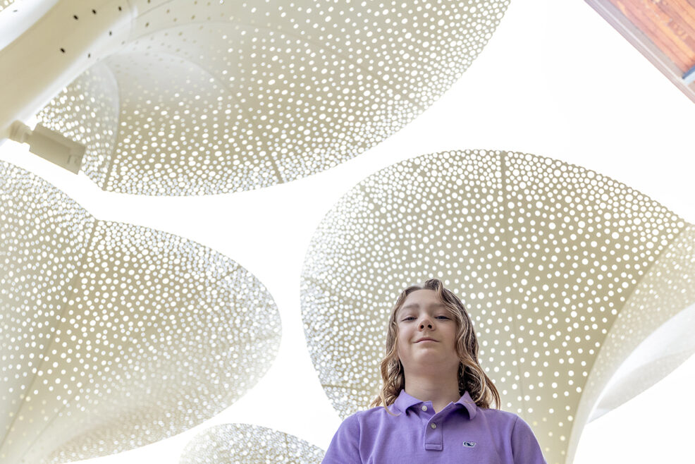 child standing under the Petals sculptures at the Blanton Museum