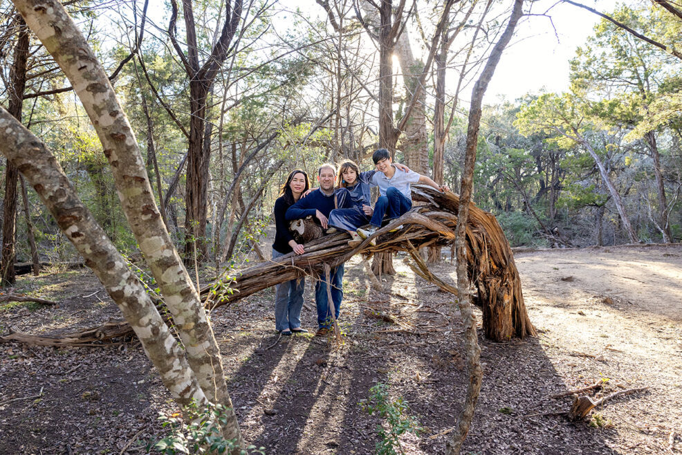 family posed around a tree branch