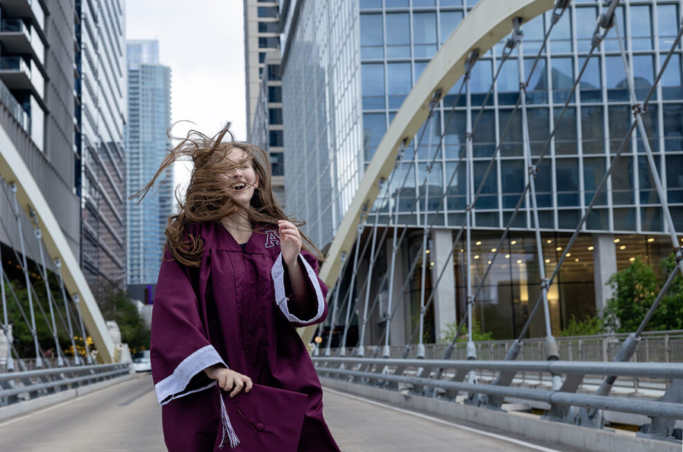 wind blown senior hair on the butterfly bridge in austin, texas for cap and gown senior photo session