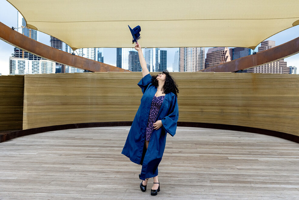 cap and gown senior on 3-D printed stage at the Long Center in Downtown Austin, Texas