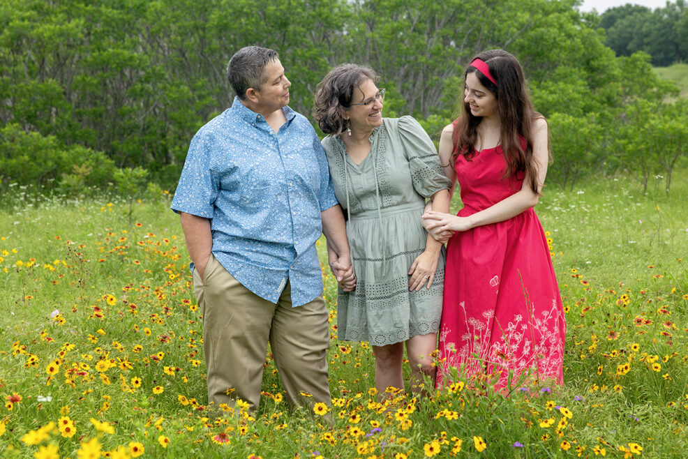 family of three in yellow wildflower field in austin texas