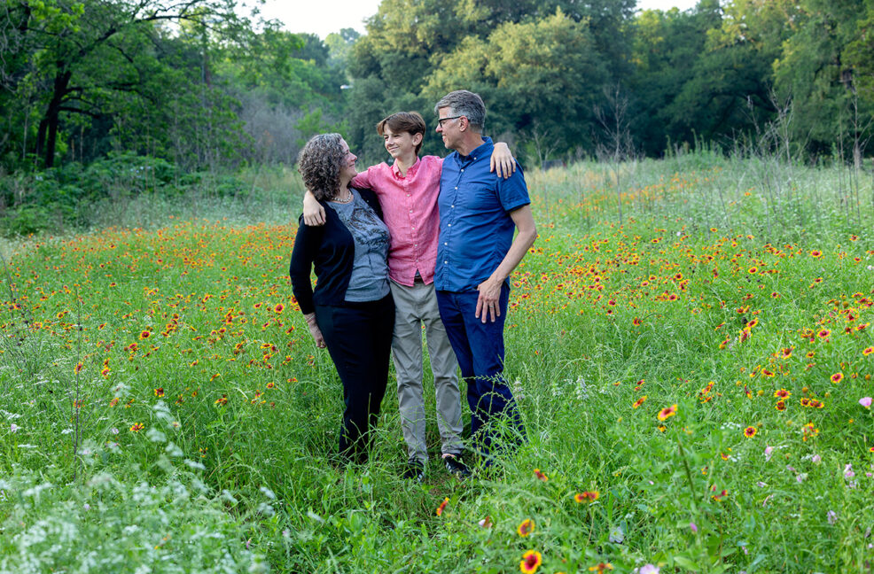 family of three in field of wildflowers in pease park in austin texas