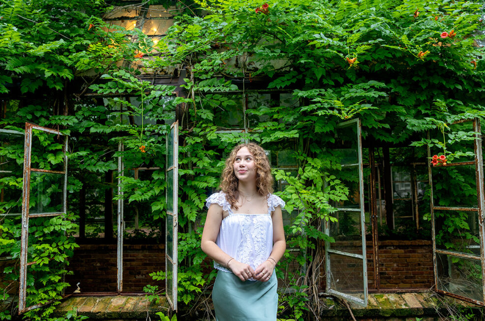 high school senior glass greenhouse covered in ivy for photo session in east austin
