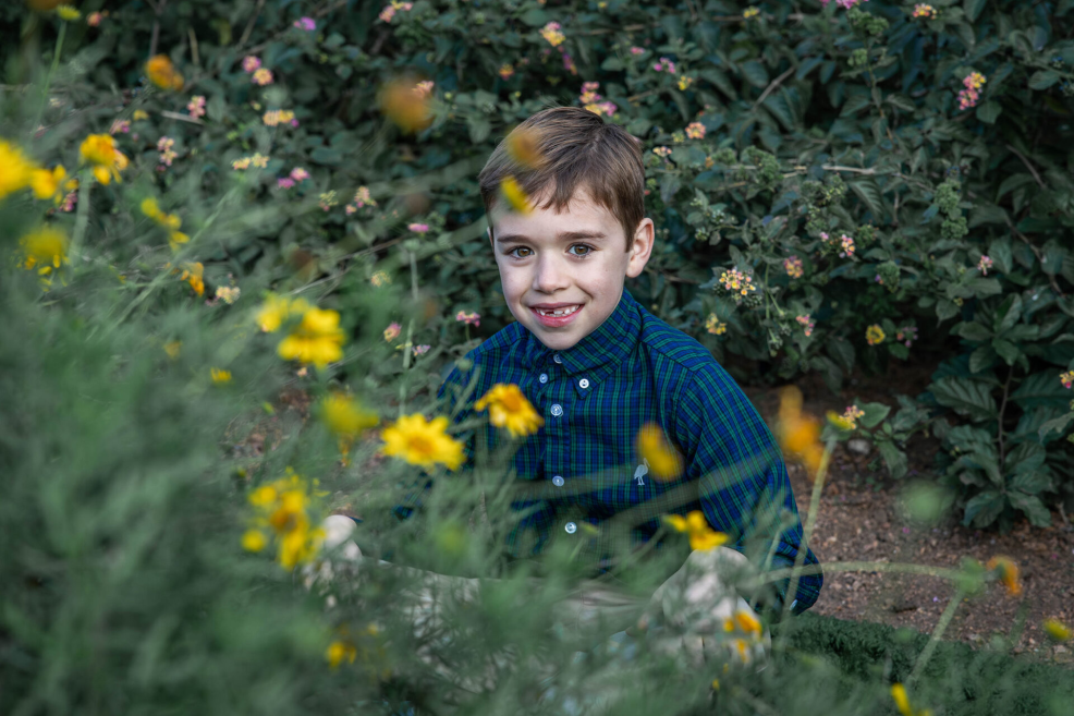 kid in flowers at family photo session in austin