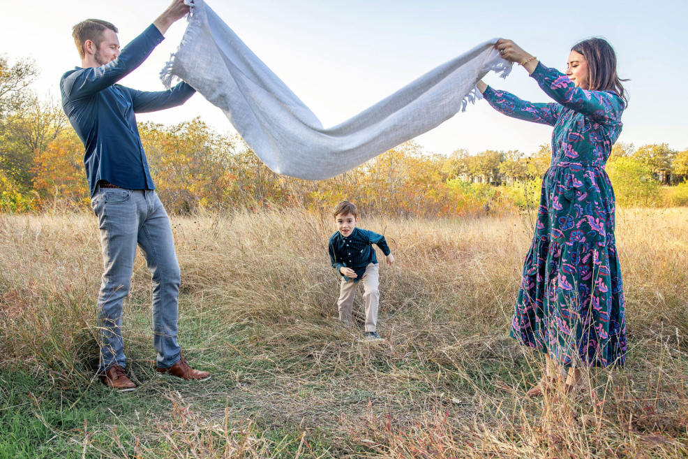 kid running under a blanket at a family photo session at a park in austin by stephanie friedman photography