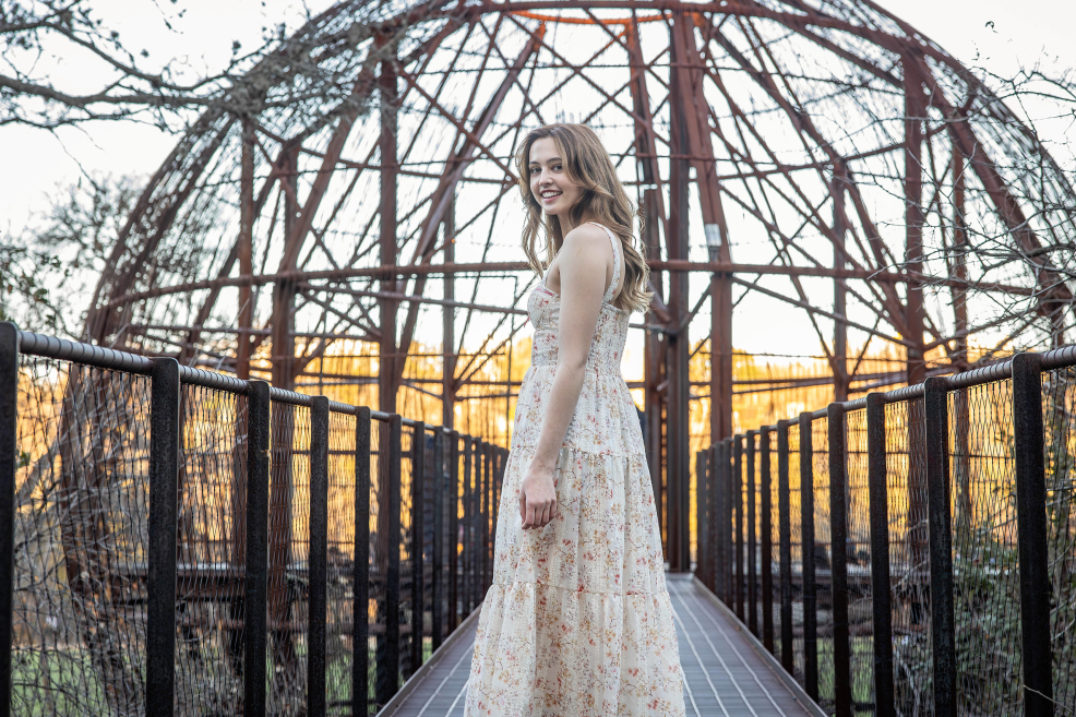 high school girl in front of the metal treehouse pod at pease park in central austin