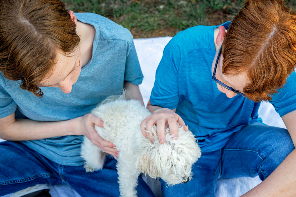 brothers holding family dog during photo session at park in austin