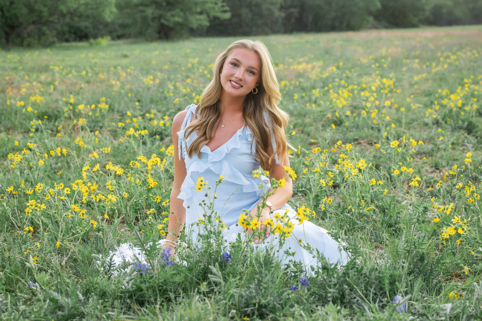high school senior girl in a field of yellow wildflowers at mckinney falls state park